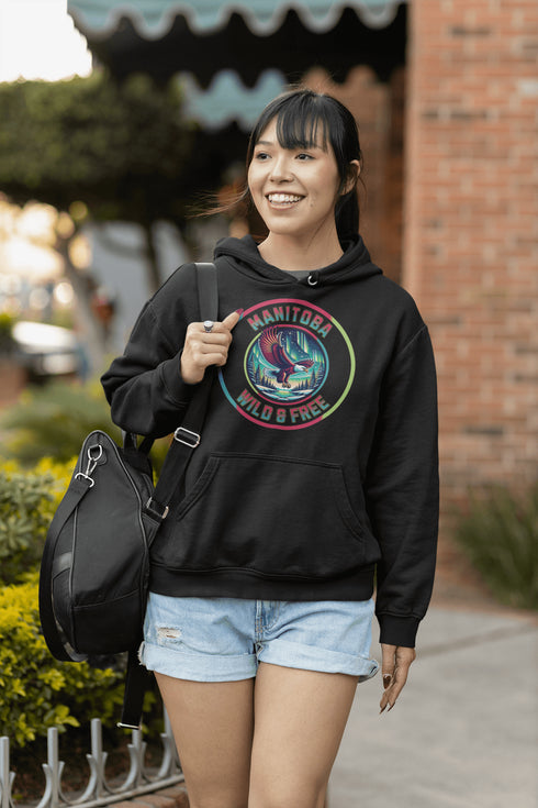 Soar high in our Manitoba – Wild & Free hoodie, featuring a bold flying bald eagle beneath the captivating northern lights.